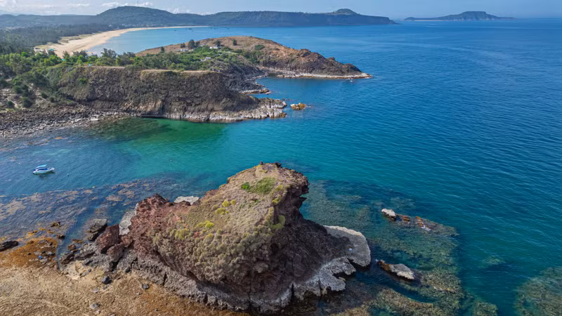 Lying about 50 metres closer to shore is Hon Dun, an islet covering approximately 0.1 hectares and rising some 20 metres above sea level. When the tide recedes, the shallow waters between the mainland and the two islets reveal a distinctive exposed rocky shoal.