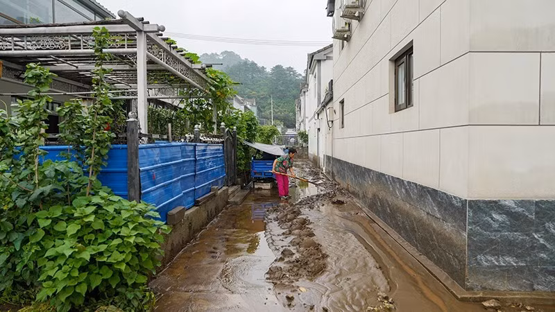 A woman clears mud after flood recedes in Beijing, China. (Photo: Xinhua)