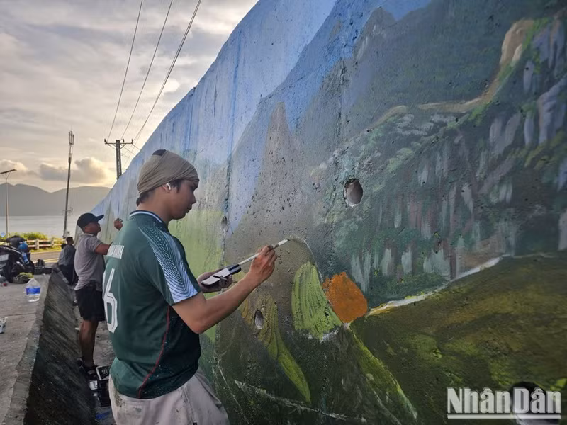 Artists put the finishing touches to the mural. (Photo: Le Dinh Thin)