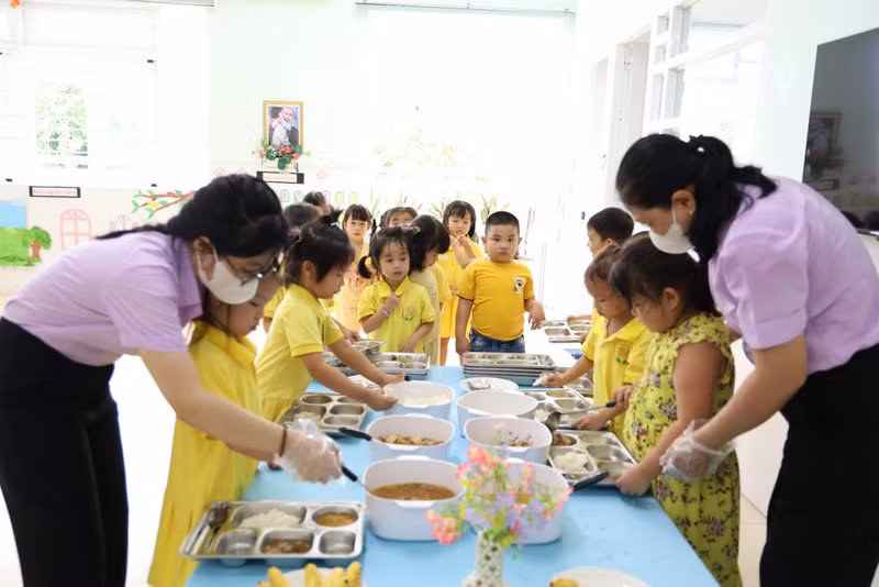 Teachers at Phu My Kindergarten assists pupils prepare their lunch. (Photo: QUANG QUY)