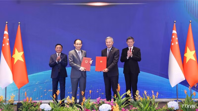 Minister of Foreign Affairs Le Hoai Trung and his Singaporean counterpart Vivian Balakrishnan exchange a Memorandum of Understanding on cooperation between the two Parties. (Photo: Phuong Hoa/VNA)