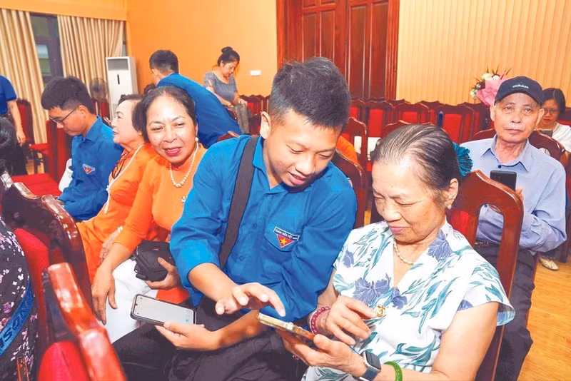 Youth union members in Tay Ho Ward, Ha Noi, administer digital skills instruction for older people.