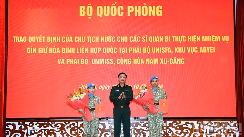 Deputy Minister of National Defence Sen. Lt. Gen. Nguyen Truong Thang presents the decisions to the two officers on October 23, 2026. (Photo: The Dai)