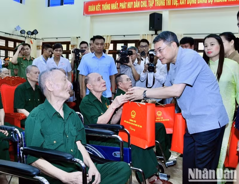 Prime Minister Le Minh Hung talks with invalids and sick soldiers receiving treatment at Kim Bang Invalids Nursing Centre in Ninh Binh province. (Photo: Thanh Giang) 