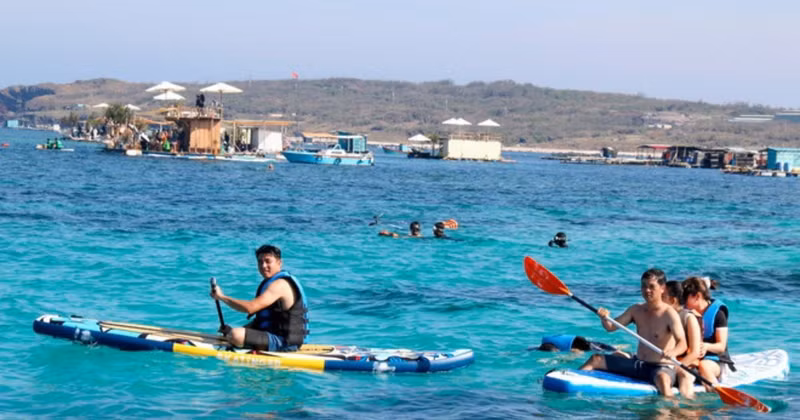 Visitors experience coral-reef diving and stand-up paddleboarding in the Bai Can area, Phu Quy. (Photo: TTXVN)