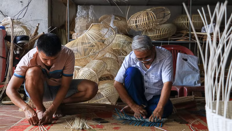 Artisans weave bamboo and rattan products at Phu Vinh Village in Ha Noi. (Photo: Ha Nam)