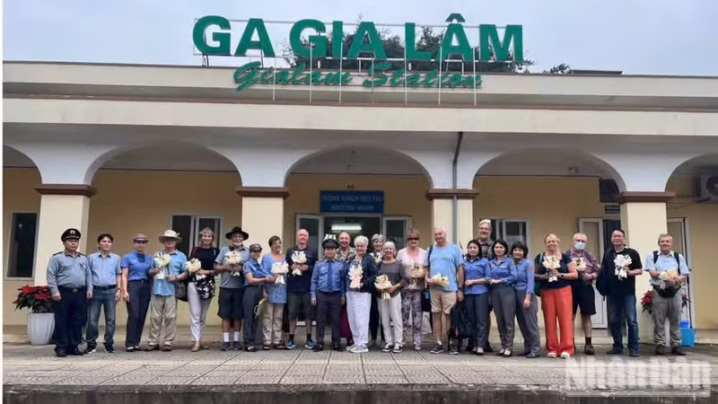 Train manager Nguyen Manh Hung and the SP3 crew pose for a commemorative photograph with an international tour group.
