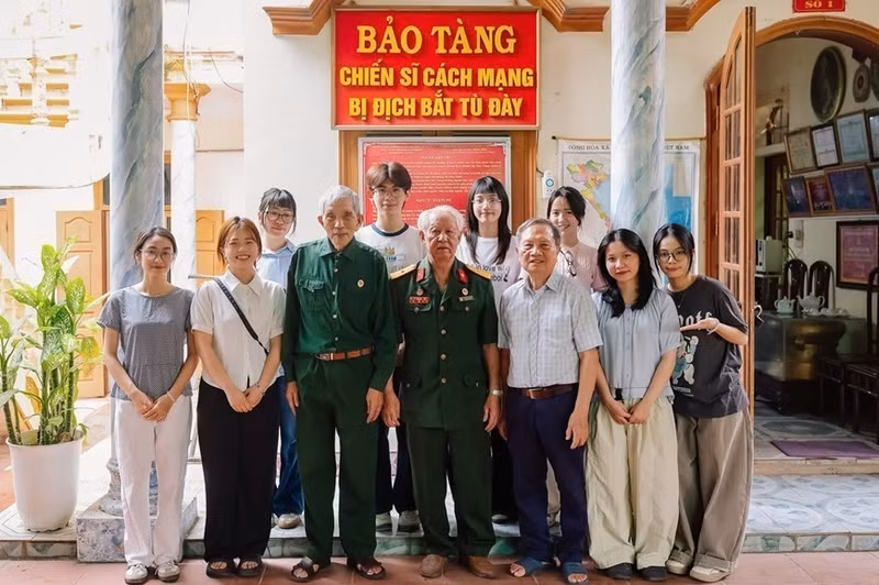 Members of the "Stories of Peace" project join a group photo with war veterans at the Museum of Revolutionary Soldiers Captured and Imprisoned by the Enemy (Photo: qdnd.vn)