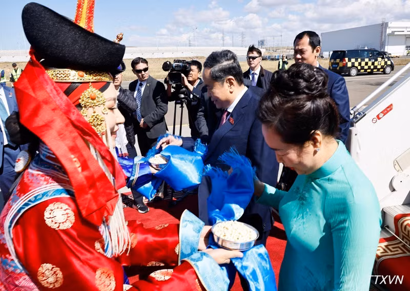 Two Mongolian girls present National Assembly President Tran Thanh Man and his spouse with khadag scarves and offer them aaruul, a Mongolian snack, as part of the country’s traditional welcoming ceremony. (Photo: VNA)