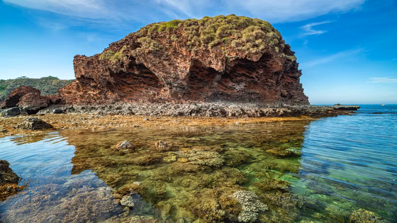 The exposed coral reef set against the emerald-green waters creates a breathtaking natural spectacle.
