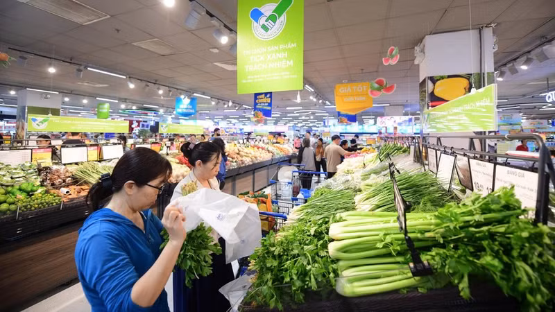 People buy food at a stall displaying the “Responsible Green Tick” label. (Photo: QUANG DINH)