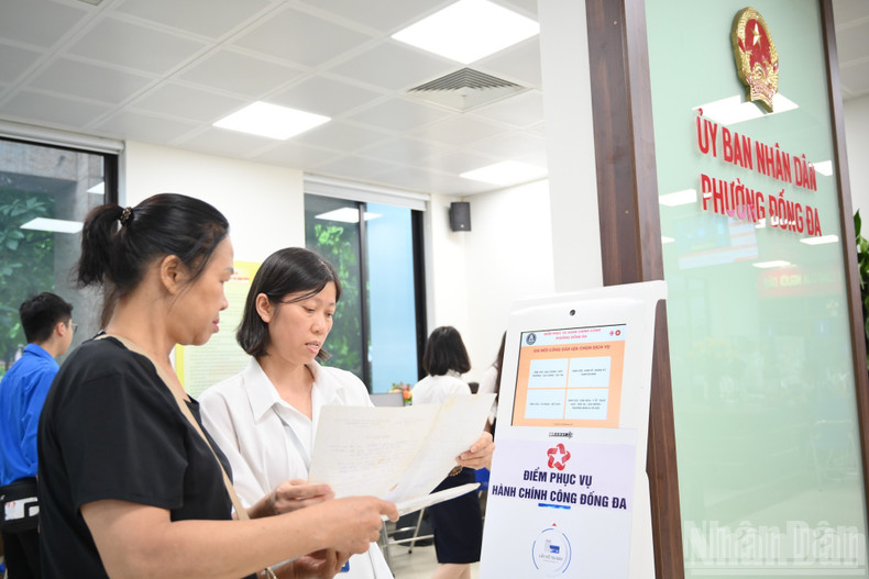 An IT technician configures the population and administrative boundary data system, assisting citizens to look up at the one-stop department. ndo-br-chinh-quyen-2-cap-7067.jpg
