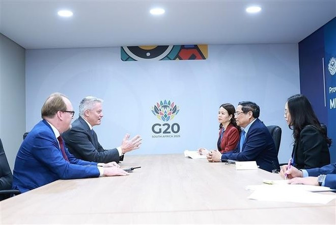 At the meeting between Vietnamese Prime Minister Pham Minh Chinh (second, right) and Secretary-General of the Organisation for Economic Cooperation and Development (OECD) Mathias Cormann in Johannesburg on November 23. (Photo: VNA)
