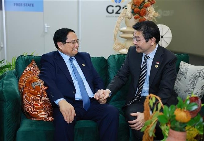 Vietnamese Prime Minister Pham Minh Chinh (L) and his Singaporean counterpart Lawrence Wong in Johannesburg on November 23. (Photo: VNA)