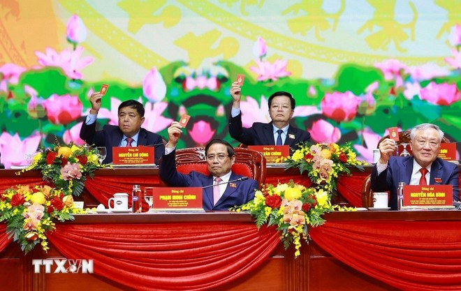 The Presidium vote to approve the congress's resolution. (Photo: VNA) The Presidium vote to approve the congress's resolution. (Photo: VNA)