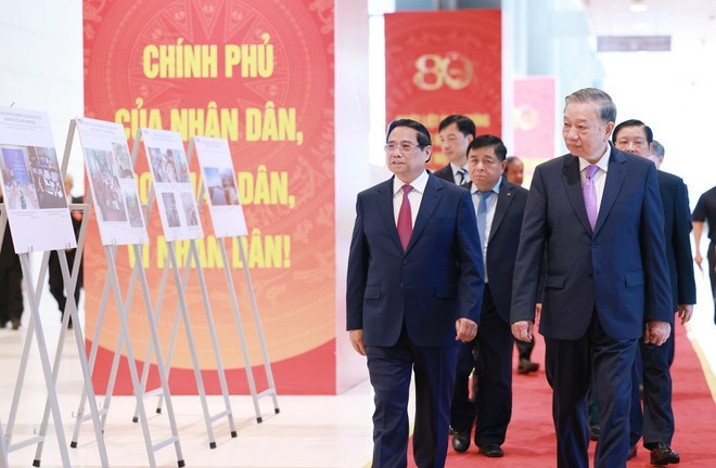 Party General Secretary To Lam (R) and PM Pham Minh Chinh, together with other delegates, visit a photo exhibition on the activities of the Government throughout history. (Photo: VNA) Party General Secretary To Lam (R) and PM Pham Minh Chinh, together with other delegates, visit a photo exhibition on the activities of the Government throughout history. (Photo: VNA)