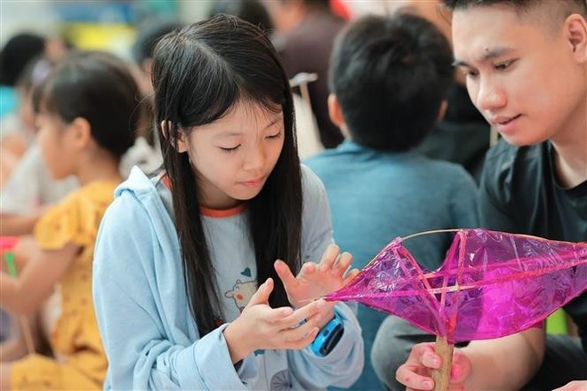 Children experience making fish-shaped lanterns. (Photo: VNA) Children experience making fish-shaped lanterns. (Photo: VNA)