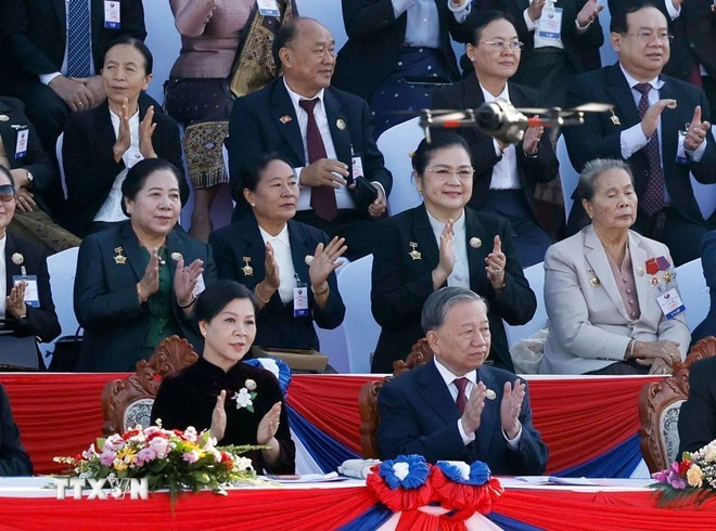 Party General Secretary To Lam and his spouse at the celebration of Laos&apos; 50th National Day anniversary (Photo: VNA)