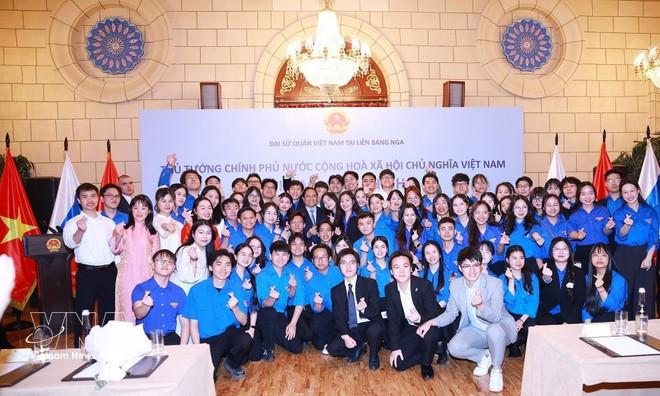 PM Pham Minh Chinh and Vietnamese students in Russia pose for a photo at the meeting. (Photo: VNA)