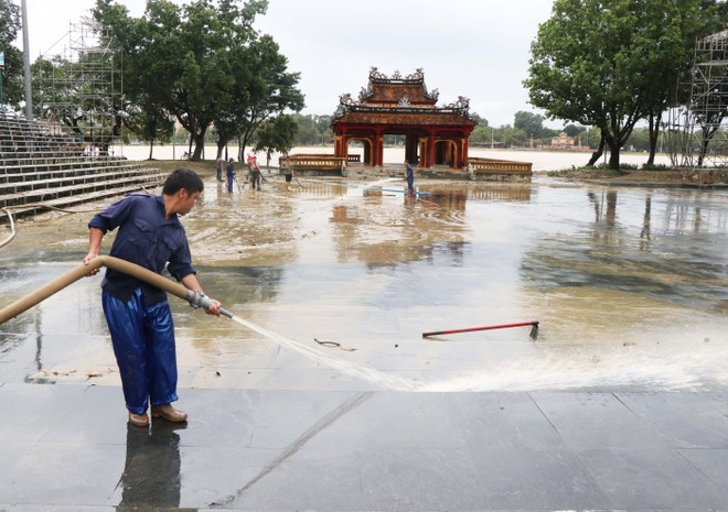 Workers wash mud from the Nghinh Luong Dinh relic site in Hue city (Photo: VNA)