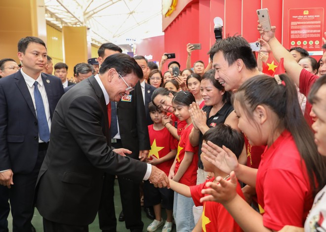 Party General Secretary and President of Laos Thongloun Sisoulith meets Vietnamese people at the exhibition. (Photo: VNA) Party General Secretary and President of Laos Thongloun Sisoulith meets Vietnamese people at the exhibition. (Photo: VNA)