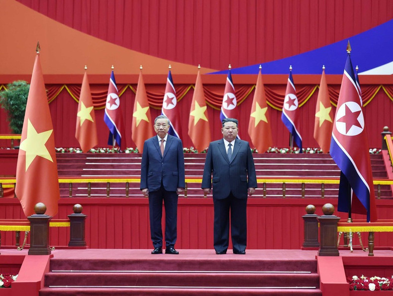 General Secretary To Lam and General Secretary of the Workers’ Party of Korea and President of the State Affairs of the Democratic People’s Republic of Korea Kim Jong Un stand on the ceremonial platform as the military band plays the national anthems of both countries. (Photo: VNA) vna-potal-le-don-tong-bi-thu-to-lam-tham-cap-nha-nuoc-toi-chdcnd-trieu-tien-8327297.jpg