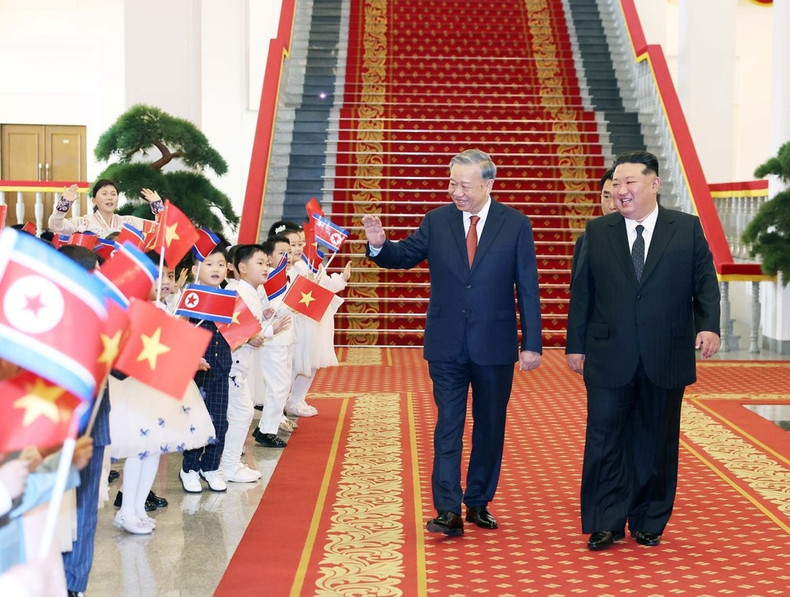 Korean children wave at General Secretary of the Communist Party of Viet Nam Central Committee To Lam (right) and General Secretary of the Workers’ Party of Korea and President of the State Affairs of the Democratic People's Republic of Korea Kim Jong Un at the welcome ceremony. (Photo: VNA) vna-potal-le-don-tong-bi-thu-to-lam-tham-cap-nha-nuoc-toi-chdcnd-trieu-tien-8327321.jpg