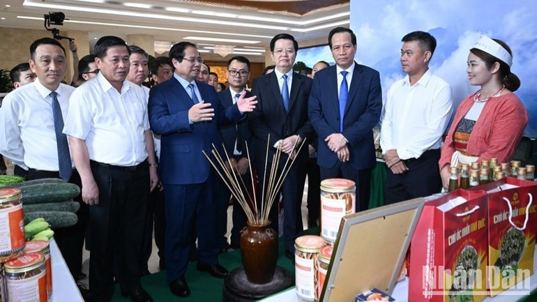Prime Minister Pham Minh Chinh and officials visit a booth showcasing OCOP products by producers from ethnic minority groups on the conference's sidelines. (Photo: Tran Hai) ndo-br-a2-804-3533.jpg