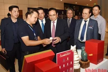 Prime Minister Pham Minh Chinh visits an exhibition showcasing the national branded products. (Photo: NDO)