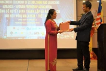 Vietnamese Ambassador to Malaysia Tran Viet Thai hands over the congratulatory letters from the Vietnamese Ministry of Foreign Affair to Chairwoman of the Malaysia-Vietnam Friendship Association Tran Thi Chang (Photo: VNA) 