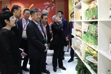 Representatives of Singaporean businesses visit a Vietnamese booth on the sidelines of conference. (Photo: VNA)