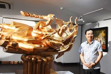 Painter and sculptor Dinh Gia Thang beside his sculpture “Roots of Happiness.”