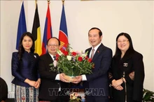 Vietnamese Ambassador to Belgium and Luxembourg Nguyen Van Thao (R) presents flowers to Lao Ambassador to Belgium and the EU Phoukhong Sisoulath at the exchange event. (Photo: VNA) 