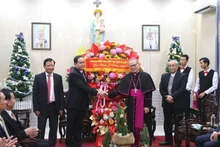 Politburo member, Permanent Vice Chairman of the National Assembly Tran Thanh Man (L) delivers Christmas wishes to Archbishop Joseph Nguyen Chi Linh. (Photo: VNA)