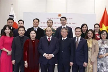 President Nguyen Xuan Phuc (fourth from left) and representatives of the Vietnamese Embassy and people in the RoK pose for a photo at the meeting on December 4. (Photo: VNA)