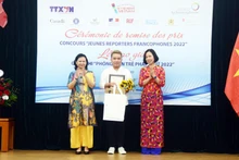 The first-prize winner Ho Ngoc Vinh Nguyen (centre) receive his award from VNA General Director Vu Viet Trang (R) and Tran Thi Mai Yen, acting Chief Representative of the OIF in the Asia-Pacific region. (Photo: VNA) 