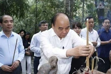 President Nguyen Xuan Phuc offers incense in commemoration of President Ho Chi Minh at Na Nua tent in Tan Trao relic site. (Photo: VNA)