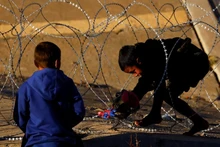 A migrant boy tries to cross a barbed wire that was placed by the Texas National Guard on the border between the US and Mexico with the purpose of reinforcing border security and inhibiting the crossing of migrants into the US, January 7, 2023. (Photo: REUTERS)