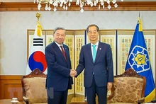 Minister of Public Security To Lam (L) and Prime Minister of the RoK Han Duck-soo (Photo: VNA)