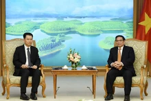 PM Pham Minh Chinh (R) and Lao Minister of Industry and Commerce Malaythong Kommasith at the meeting in Hanoi on December 23. (Photo: NDO)