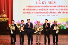 Politburo member Vo Van Thuong and Party official Nguyen Trong Nghia presents honourary badges to five senior officials in the book publishing sector. (Photo: the organising board)