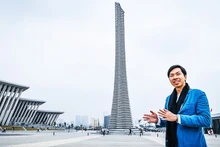 Architect Trinh Viet A beside the monumental structure designed by him and his colleagues.