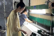 Tran Minh Nhi, founder of Du Nhien, carefully studies every stage of the silk weaving process to select the finest products.