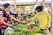 A woman shops for vegetables at a market in Ho Chi Minh City. (Photo: NDO)
