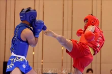 Bui Truong Giang (in red) brought home the fourth gold for Vietnamese Wushu team after taking down Gideon Fred Wayan Padua of the Philippines in combat event. (Photo: VNA)