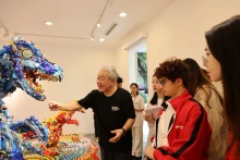 Artist Hiroshi Fuji introduces his artworks to visitors at the exhibition 