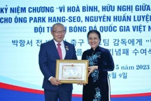 Ambassador Nguyen Phuong Nga (right) presents the insignia to coach Park Hang-seo. (Photo: VNA)
