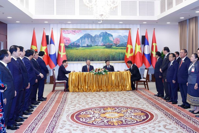 General Secretary of the Communist Party of Viet Nam Central Committee To Lam (second, left) and General Secretary of the Lao People&apos;s Revolutionary Party Central Committee and President of Laos Thongloun Sisoulith witness the signing of an agreement between the two Parties&apos; Politburo. (Photo: VNA)