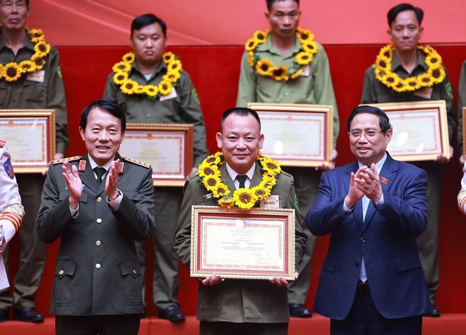 Prime Minister Pham Minh Chinh and Minister of Public Security Luong Tam Quang honour and present awards to outstanding collectives and individuals in grassroots-level security and orderprotection. (Photo: VNA)