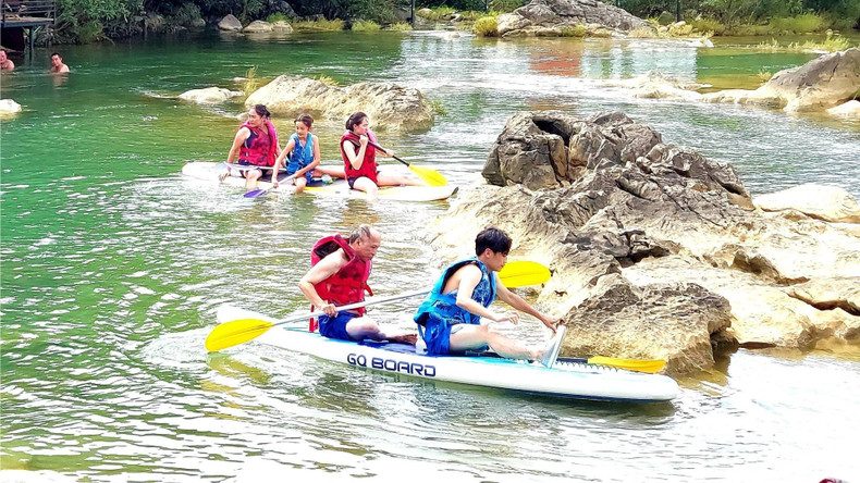 Visitors enjoy stand-up paddleboarding (SUP) at Cold Water Stream. (Photo: nhandan.vn) cheosupquangbinh-28725.jpg
